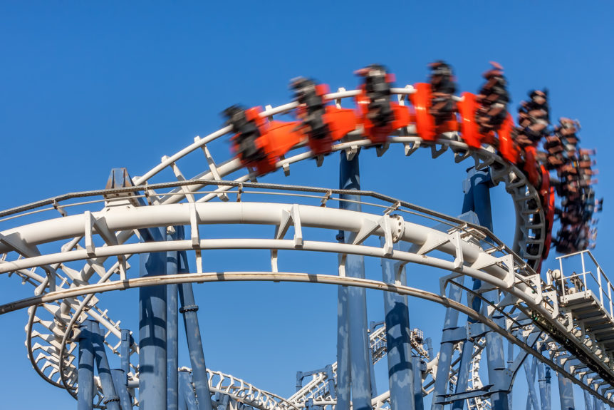 Roller coaster ride under blue sky.