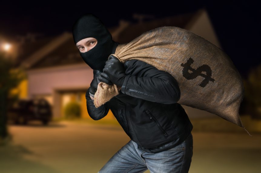 Robber is running away and carying full bag of money at night.